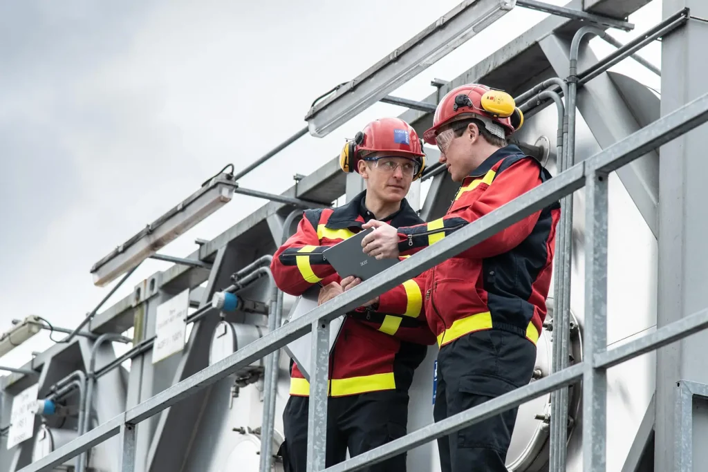 Zwei Personen stehen auf dem Balkon eines industriellen Gebäudes